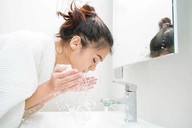 Rửa mặt bằng nước m&aacute;t ngay khi bị dị ứng kem chống nắng