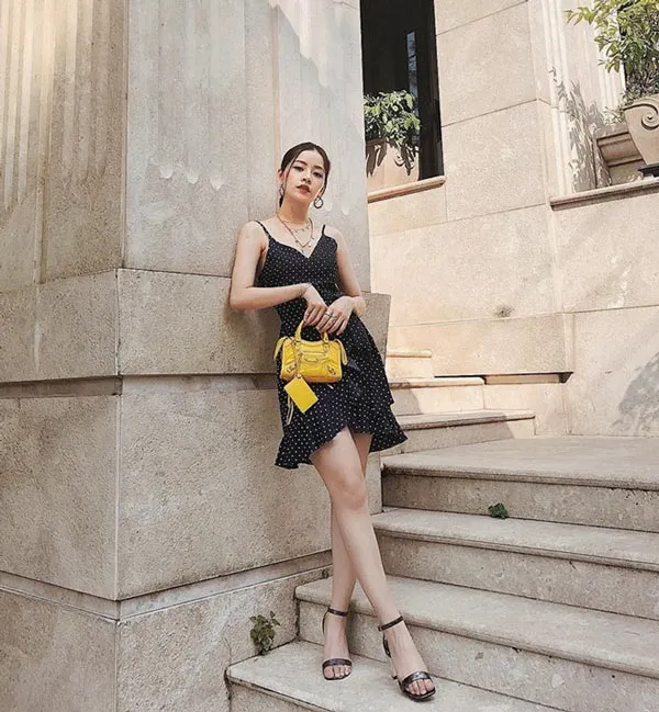 Đầm đen phối với t&uacute;i x&aacute;ch v&agrave;ng năng động