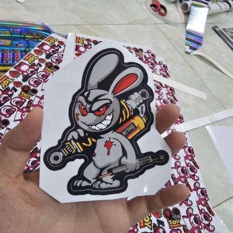 Tem Sticker Thỏ Điên Cầm Phuộc 10cm - Tem Dán 3 Lớp Cao Cấp, Chống Nước, Bảo Hành Trọn Đời, Trang Trí Ô Tô, Xe Máy, Xe Đạp
