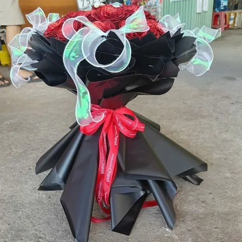 bó hoa hồng phủ nhũ kim tuyến đỏ được thiết kế theo dáng bó công chúa kết hợp tone đen sang trọng 20 bông